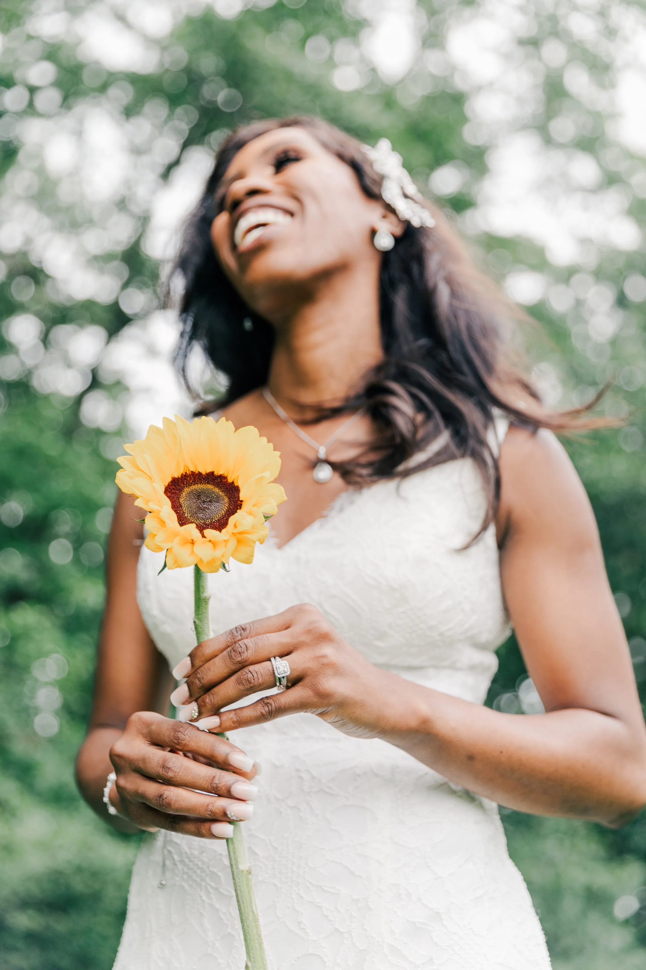 Bride laughing while holding a sunflower